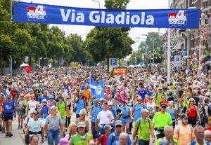 Op deze foto zie je wandelaars over de Via Gladiola tijdens de laatste dag van de 103e editie van de Nijmeegse Vierdaagse. Is wandelen een workout? Zoveel calorieën verbrand je ermee