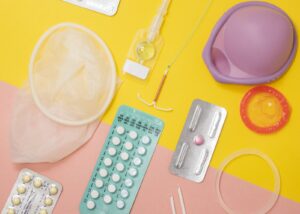 Op deze foto zijn meerdere vormen van anticonceptie te zien, zoals de pil, het condoom en een spiraaltje. mannenpil