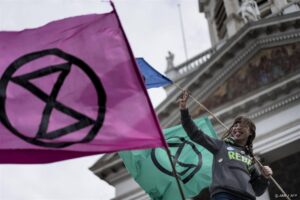 An activist from the climate change action group Extinction Rebellion holds a flag during a protest at the Place Royale in Brussels on October 12, 2019.   
 
Kenzo TRIBOUILLARD / AFP