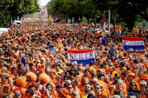 HAMBURG - Oranje fans lopen achter de Oranjebus tijdens de fanwalk naar het Volksparkstadion voor de eerste wedstrijd op het EK van het Nederlands elftal tegen Polen. ANP RAMON VAN FLYMEN