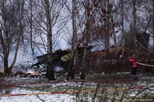 A Lithuanian medic takes a photo on his mobile phone of the wreckage of a cargo plane following its crash near the Vilnius International Airport in Vilnius on November 25, 2024. 
Petras Malukas / AFP