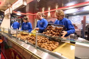 DEN HAAG - Klanten in de rij bij Vermolens oliebollenkraam in Den Haag op oudjaarsdag. Hoewel bijna alles duurder is geworden, kopen Nederlanders dit jaar net zoveel oliebollen als vorig jaar. ANP PHIL NIJHUIS